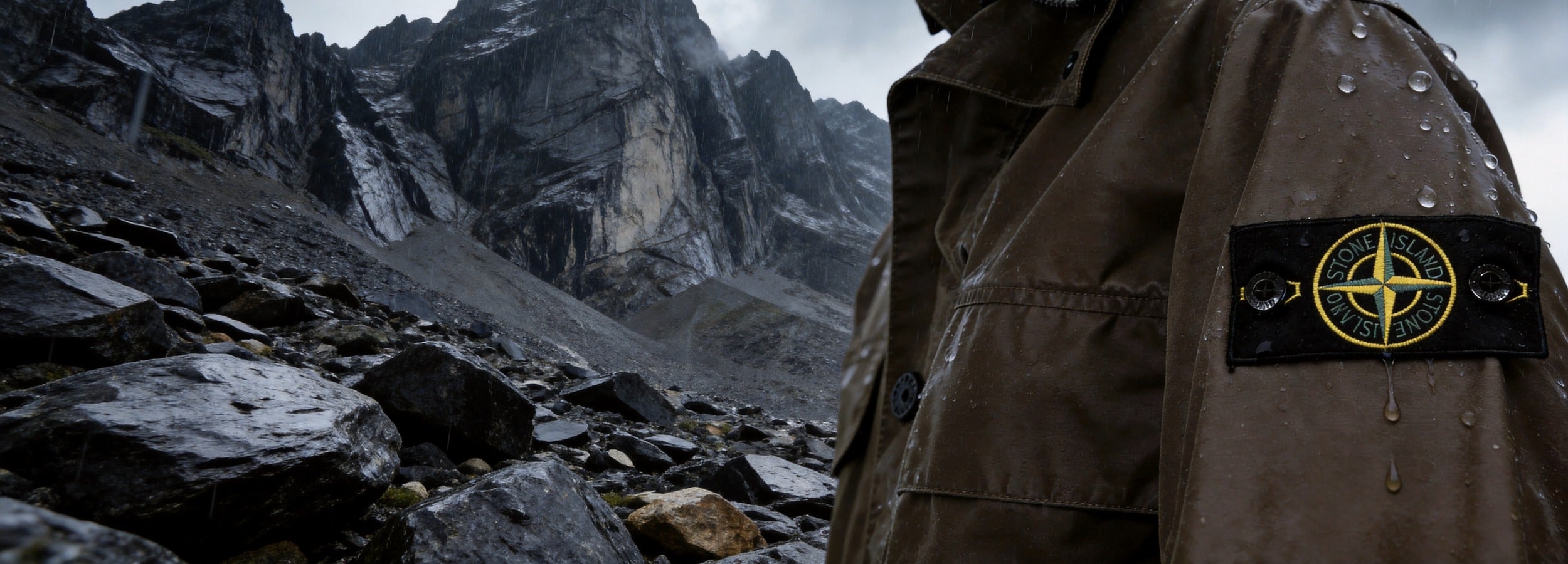 Stone Island T-shirts bij Gentlemen Mode — authentieke kompasbadge in ruige alpine regen